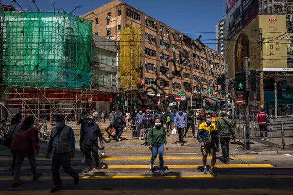 پوشیدن ماسک صورت در هنگ کنگ در روز سه‌شنبه. دو سال پس از اعلام همه‌گیری، این شهر بدترین شیوع خود را تجربه می‌کند.